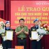 Thượng tướng Lương Tam Quang, Thứ trưởng Bộ Công an trao Quyết định của Chủ tịch nước cho 2 sỹ quan Công an Nhân dân đi thực hiện nhiệm vụ gìn giữ hòa bình Liên hợp quốc. (Ảnh: TTXVN phát)