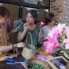 Thanh Nhàn (áo xanh) đang giao tiếp với các bạn khuyết tật bằng ngôn ngữ ký hiệu. (Ảnh: Tường Vi/TTXVN)
