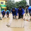 Hàng trăm người gồm bộ đội, công an, dân quân tự vệ, đoàn thanh niên... được huy động hỗ trợ dọn bùn, giúp người dân thành phố Yên Bái sớm ổn định cuộc sống sau đợt lũ. (Ảnh: Tuấn Anh/TTXVN)