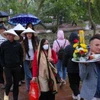 Mặc dù trời mưa nhẹ nhưng chiều tối ngày 14 tháng Giêng đông đảo du khách đến đền Trần để tham quan, vãn cảnh. (Ảnh: Công Luật/TTXVN)