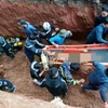 Lực lượng chức năng triển khai công tác cứu nạn cứu hộ đưa nạn nhân lên mặt đất. (Ảnh TTXVN phát)