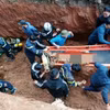 Lực lượng chức năng triển khai công tác cứu nạn cứu hộ đưa nạn nhân lên mặt đất. (Ảnh TTXVN phát)
