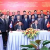 Thượng tướng Võ Minh Lương (phải), Thứ trưởng Bộ Quốc phòng, Trưởng ban Ban Công tác đặc biệt Chính phủ Việt Nam và Thượng tướng Thongloi Silivong (trái), Thứ trưởng Bộ Quốc phòng, Chủ nhiệm Tổng cục Chính trị QĐND Lào, Trưởng ban Ban Công tác đặc biệt Chính phủ Lào, ký Biên bản Kỳ họp. (Ảnh: Xuân Khu/TTXVN)