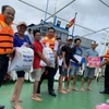 Các chiến sỹ hải quân công tác trên huyện đảo Trường Sa hỗ trợ lương thực, thực phẩm cho ngư dân Bình Thuận. (Ảnh: TTXVN phát)