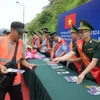 Cán bộ Đồn Biên phòng Tân Thanh, tỉnh Lạng Sơn, tuyên truyền, phát tờ rơi pháp luật biên giới tại cửa khẩu. (Ảnh: Quang Duy/TTXVN)
