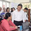Phó Chủ tịch UBND thành phố Hà Nội Hà Minh Hải trao đổi với người dân làm thủ tục hành chính tại UBND phường Quảng An, quận Tây Hồ, Hà Nội. (Ảnh: Nguyễn Thắng/TTXVN)
