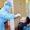 Nhân viên y tế lấy mẫu xét nghiệm của trường hợp F1. (Ảnh: Hoa Mai/TTXVN)