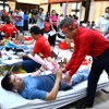 Ông Lê Văn Hậu, Phó trưởng Ban chỉ đạo vận động hiến máu tình nguyện, Chủ tịch Hội Chữ thập đỏ tỉnh Bà Rịa-Vũng Tàu tặng hoa tri ân tình nguyện viên tham gia hiến máu cho ngày hội chính. (Ảnh: Huỳnh Sơn/TTXVN)