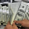 Nhân viên kiểm đồng USD tại một ngân hàng. (Ảnh: AFP/TTXVN)
