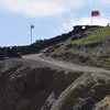 Quốc kỳ Azerbaijan (trái) và quốc kỳ Armenia tại trạm kiểm soát biên giới giữa hai nước ở làng Sotk (Armenia). (Ảnh: AFP/TTXVN) 