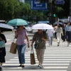 Người dân che ô tránh nắng nóng trên đường phố tại Seoul, Hàn Quốc. (Ảnh: Yonhap/TTXVN)