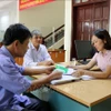 Cán bộ Ngân hàng Chính sách Xã hội hướng dẫn người dân thủ tục vay vốn. (Ảnh: TTXVN)