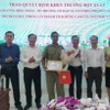 Lãnh đạo huyện Bù Đăng khen thưởng đột xuất cho hành động dũng cảm của anh Nhân. (Ảnh: TTXVN phát.)