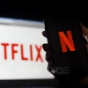 Biểu tượng Netflix trên màn hình máy tính và điện thoại di động. (Ảnh: AFP/ TTXVN)