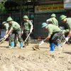 Hàng trăm người gồm bộ đội, công an, dân quân tự vệ, đoàn thanh niên... được huy động hỗ trợ dọn bùn, giúp người dân thành phố Yên Bái sớm ổn định cuộc sống sau đợt lũ. (Ảnh: Tuấn Anh/TTXVN)