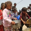 Trẻ em nhận thực phẩm cứu trợ tại thành phố Rafah, Dải Gaza ngày 19/5/2024. (Ảnh: THX/TTXVN)