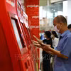 Hành khách làm thủ tục trực tuyến tại kios của Vietjet tại sân bay Nội Bài. (Ảnh: Huy Hùng/TTXVN)