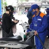 Nhân viên Petrolimex bán xăng cho khách hàng. (Ảnh: Đức Duy/Vietnam+)