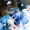 Các bác sỹ tiến hành phẫu thuật. (Ảnh: Đinh Hằng/TTXVN)
