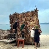 Lực lượng Biên phòng Cô Tô giúp người dân chằng chống cơ sở kinh doanh tại bãi biển Hồng Vàn. (Ảnh: TTXVN phát)