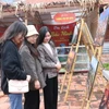 Du khách tham quan khu trưng bày ảnh về văn hóa Bắc Ninh tại Trung tâm Bảo tồn tranh dân gian Đông Hồ, thị xã Thuận Thành. (Ảnh: Thanh Thương/TTXVN)