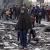 Người dân Palestine bên đống đổ nát của những tòa nhà bị phá hủy sau các cuộc không kích của Israel tại thành phố Rafah, Dải Gaza. (Ảnh: THX/TTXVN)