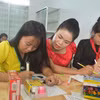 Cô Hoàng Thị Bảy hướng dẫn học sinh làm bài. (Ảnh: Nguyên Dung/TTXVN)