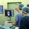 Cán bộ y tế hội chẩn kết quả chụp CT khớp gối của bệnh nhân tại Bệnh viện Bach Mai. (Ảnh: Dương Ngọc/TTXVN) 