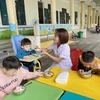 Các cô giáo tại Làng Trẻ em Mồ côi Hà Tĩnh chăm sóc trẻ trong giờ ăn trưa. (Ảnh: Hữu Quyết/TTXVN)