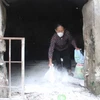 Người dân rắc vôi phòng chống dịch ở chuồng trại chăn nuôi. (Ảnh: Công Tường/TTXVN)