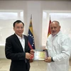 Phó Trưởng Ban Dân vận Trung ương Nguyễn Lam tặng quà lưu niệm Phó Chủ tịch thứ nhất Đảng PSUV Diosdado Cabello Rondón. (Nguồn: Đại sứ quán Việt Nam tại Venezuela)
