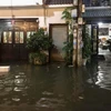 Triều cường gây nước ngập tràn vào nhà dân tại một tuyến hẻm trên đường Trần Xuân Soạn (Quận 7). ( Ảnh: Hồng Giang/TTXVN)