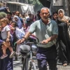Người dân sơ tán khỏi khu vực phía Đông thành phố Gaza. (Ảnh: THX/TTXVN)