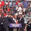 Mật vụ Mỹ bảo vệ cựu Tổng thống Donald Trump rời khỏi bục diễn thuyết trong cuộc vận động tranh cử ở Butler, bang Pennsylvania. (Ảnh: THX/TTXVN)