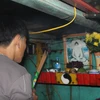 Ngư dân thực hiện nghi thức "cúng thuyền" cuối năm trong khoang lái của phương tiện. (Ảnh: Xuân Tiến/TTXVN)
