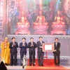 Thứ trưởng Bộ Văn hoá, Thể thao và Du lịch Hoàng Đạo Cương trao Quyết định của Thủ tướng Chính phủ công nhận bộ tượng Tam thế chùa Côn Sơn là Bảo vật quốc gia cho tỉnh Hải Dương. (Ảnh: Mạnh Minh/TTXVN)