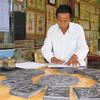 Nghệ nhân Kỳ Hữu Phước in tranh. (Ảnh: Tường Vi/TTXVN)