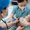 Bác sỹ khám cho bệnh nhi gần 2 tháng tuổi mắc ho gà đang điều trị tại Trung tâm bệnh Nhiệt đới (Bệnh viện Nhi Trung ương). (Ảnh: Minh Quyết/TTXVN)