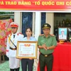 Đại tá Nguyễn Văn Hiểu trao Bằng Tổ quốc ghi công cho vợ Liệt sỹ Hồ Tấn Dương. (Ảnh: TTXVN phát)