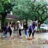 Cán bộ giáo viên Trường Tiểu học Tân Hóa (huyện Minh Hóa, Quảng Bình) vệ sinh khuôn viên trường sau khi nước rút. (Ảnh: Tá Chuyên/ TTXVN)