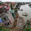 Hiện trường vụ sạt lở tại tuyến đê hữu sông Cầu đoạn qua khu Vạn Phúc, phường Vạn An (thành phố Bắc Ninh, tỉnh Bắc Ninh) khiến nhiều ngôi nhà bị rạn nứt, trôi xuống sông. (Ảnh: Thanh Thương/TTXVN)