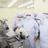 Thủ tướng Phạm Minh Chính thăm dây chuyền sản xuất chíp bán dẫn của Công ty TNHH Hana Micro Vina. (Ảnh: Dương Giang/TTXVN)