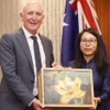 Tổng Lãnh sự Việt Nam tại Tây Australia Nguyễn Thanh Hà tặng quà lưu niệm cho Bộ trưởng Stephen Dawson. (Ảnh: TTXVN phát)