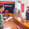 Công an đọc quyết định khởi tố vụ án đối với Trương Thị Mai Ca. (Ảnh: TTXVN phát)