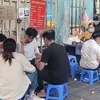 Học sinh, sinh viên hồn nhiên ngồi ăn quán xiên nướng vỉa hè quanh khu vực trường Tiểu học Lê Ngọc Hân, quận Hai Bà Trưng. (Ảnh: Phương Anh/TTXVN)