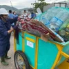 Rác được đưa lên xe, vận chuyển về Nhà thu gom rác thải nhựa tàu cá tại Cảng cá Quy Nhơn. (Ảnh: Hoàng Vân/ TTXVN)