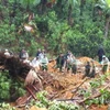 Do thời tiết mưa kéo dài nhiều ngày, vị trí đất trên đồi cao vẫn có nguy cơ bị sạt lở khiến việc tìm kiếm, khắc phục gặp nhiều khó khăn. (Ảnh: TTXVN phát)