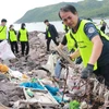 Nhân viên Ban Quản lý vịnh Nha Trang cùng các tình nguyện viên dọn rác tại khu vực bờ kè biển Vĩnh Trường, sát bến tàu du lịch Nha Trang. (Ảnh: Phan Sáu/TTXVN)
