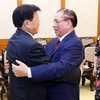 Nguyên Tổng Bí thư Nông Đức Mạnh đón Tổng Bí thư, Chủ tịch nước Lào Thongloun Sisoulith. (Ảnh: Phạm Kiên/ TTXVN)