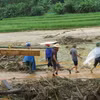 Đưa thi thể được tìm thấy sau cơn lũ dữ ở làng Nủ (Lào Cai) về an táng. (Ảnh: Hồng Ninh/TTXVN)